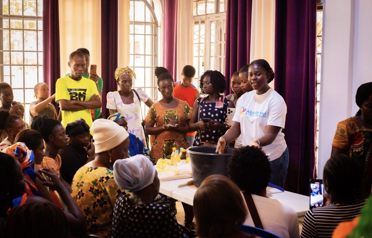 Asaase Yaa volunteer leading a hands-on skills demonstration for a group of women